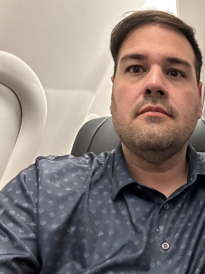 Marcio in an airplane seat, September 2024, before surgery